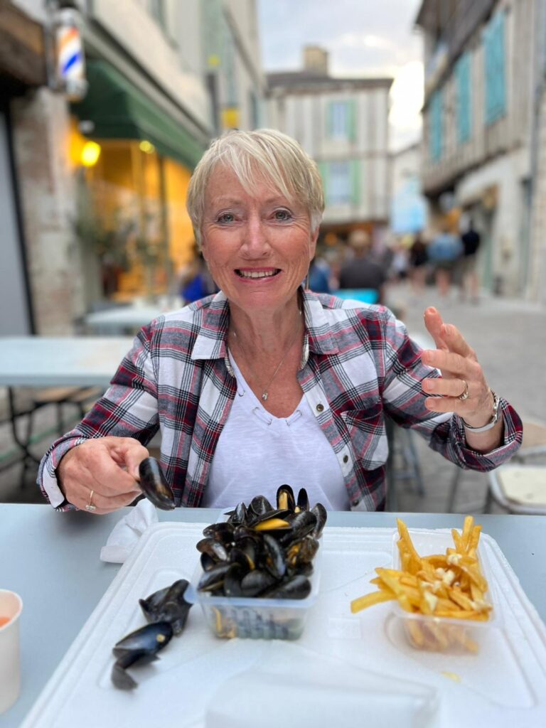 Heather eating mussels and chips outdoors