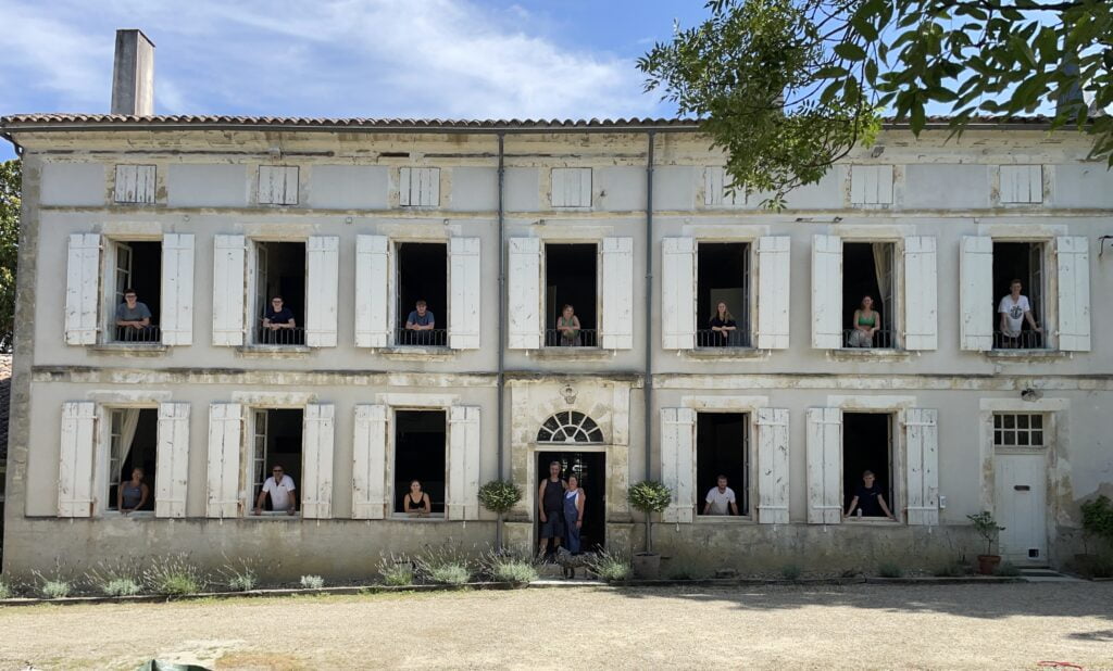 shuttered windows with people posing by every open window