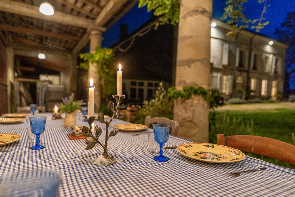 candles burning and table set on outdoor terrace dining table