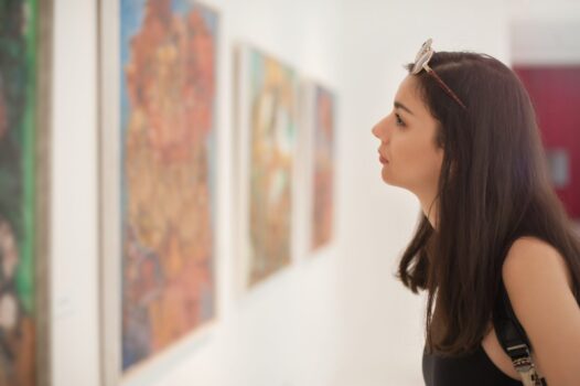 stock photo of young woman looking at modern art in gallery