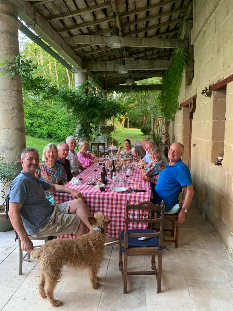 group eating lunch outdoors with dog in foreground